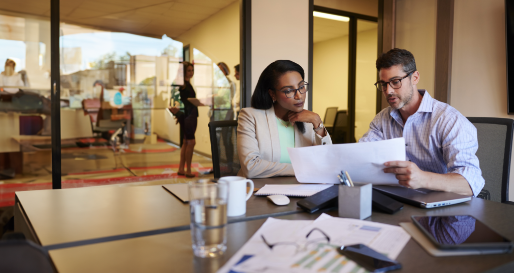 Businessman and Businesswoman going over paperwork in an office.